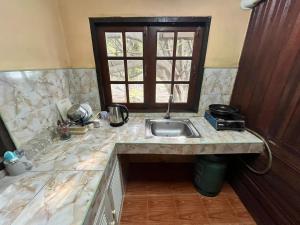 a kitchen counter with a sink and a window at Chaloklum Belvedere B6 in Ko Phangan