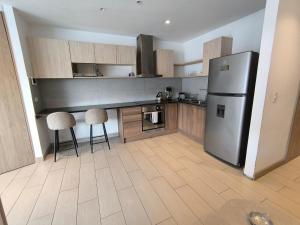 a kitchen with a refrigerator and two chairs in it at ONE Luxury Suite Super King Bed & Volcano View in Quito