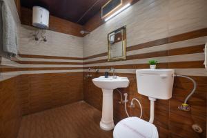 a bathroom with a toilet and a sink at Hotel Elegant Dreamscape Kasauli by Splendid Retreat Hotels in Kasauli