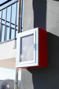 a red and white box on the side of a building at Hotel Blu Mare Shengjin in Shëngjin