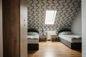 a bedroom with two twin beds and a window at Zajazd Zachęta in Kamienna Góra
