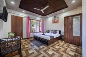 a bedroom with a king sized bed and a window at Hotel Elegant Dreamscape Kasauli by Splendid Retreat Hotels in Kasauli