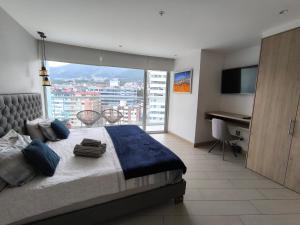 a bedroom with a bed and a desk and a window at ONE Luxury Suite Super King Bed & Volcano View in Quito