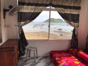 a bedroom with a window with a view of a beach at Homestay Jifiqa komodo in Komodo