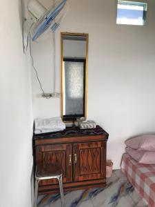 a dresser with a mirror and a chair in a room at Homestay Jifiqa komodo in Komodo