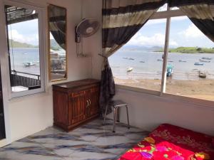 a bedroom with a window with a view of the beach at Homestay Jifiqa komodo in Komodo +5 photos