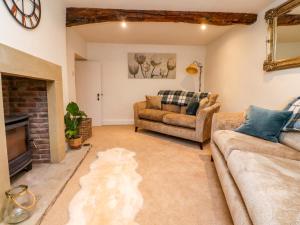 a living room with two couches and a fireplace at Cobble Cottage in Clitheroe