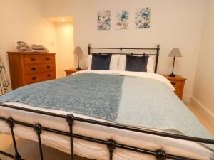 a bedroom with a large bed and two night stands at Cobble Cottage in Clitheroe