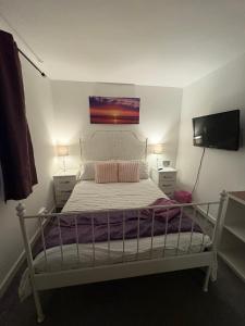 a bedroom with a bed and a tv on the wall at Abbey Meadows View ABB in Redditch