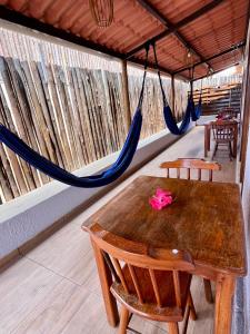 a room with a table and chairs and a hammock at Casa Brisa Noronha in Fernando de Noronha