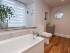 a bathroom with a tub and a toilet and a window at Cobble Cottage in Clitheroe +22 photos