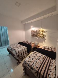 a bedroom with two beds and a chandelier at Casa Marzenta in Petrolina