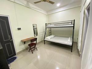 a bedroom with a bunk bed and a table at Miro Homestay in Tura