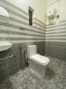a bathroom with a toilet and a sink at Miro Homestay in Tura