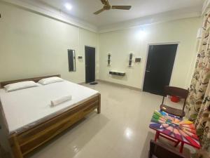 a bedroom with a bed and a chair in it at Miro Homestay in Tura