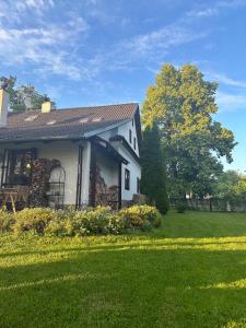 a white house with a yard and a tree at Chalupa Svratouch in Svratouch
