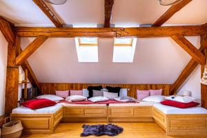 two beds in a room with wooden ceilings and windows at Chalupa Svratouch in Svratouch