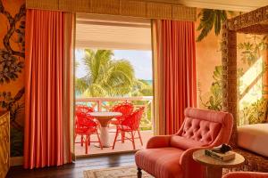ein Wohnzimmer mit Blick auf einen Balkon in der Unterkunft Coral Sands Inn & Cottages in Harbour Island