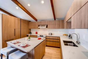 a kitchen with wooden cabinets and a white counter top at Modern Vail Village Mountain View Residence in Vail