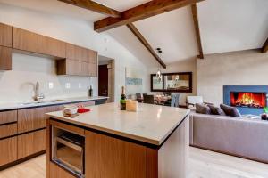 an open kitchen and living room with a fireplace at Modern Vail Village Mountain View Residence in Vail