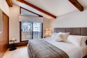 a bedroom with a large bed and a window at Modern Vail Village Mountain View Residence in Vail