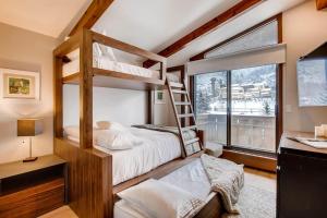 a bedroom with bunk beds with a desk and a window at Modern Vail Village Mountain View Residence in Vail +9 photos