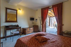 a bedroom with a bed and a desk and a mirror at Hotel A Pinnata in Lipari