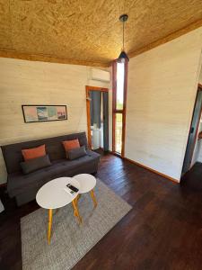 ein Wohnzimmer mit Sofa und Tisch in der Unterkunft Glass in Punta Del Diablo