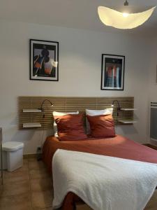 a bedroom with a large bed with red pillows at Aux Portes de La Roussille in Niort