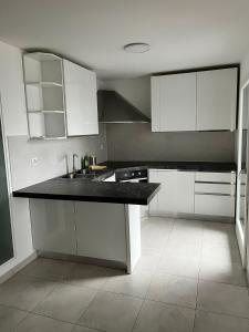 a kitchen with white cabinets and a black counter top at Via privata in Lugano