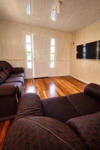 a living room with two couches and a flat screen tv at ROTA DA SERRA casa completa com ar-cond in Orleans