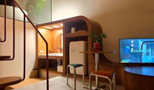 a room with a refrigerator and a table with stools at Wanderlust HAUS in Ko Larn