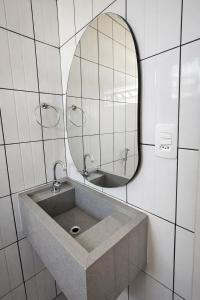 a bathroom with a sink and a mirror at ROTA DA SERRA casa completa com ar-cond in Orleans