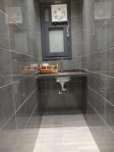 a bathroom with a sink and a clock on the wall at Elmandara Residence in Alexandria +54 photos