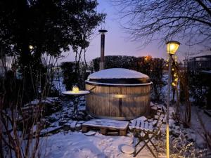 a barrel in the snow with a table and a lamp at Hanami - tuinkamer in Zwalm