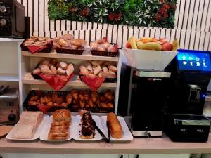 a counter with many different types of bread and pastries at Hôtel NOROTEL in Brumath