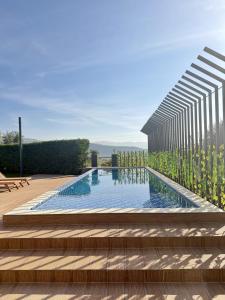 a swimming pool with stairs and a building at La Villa Kfardebian Stone Villa in Fārayyā