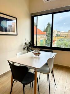 a dining room with a white table and chairs at B-eight in Batroûn