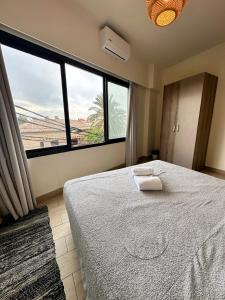 a bedroom with a bed and a large window at B-eight in Batroûn