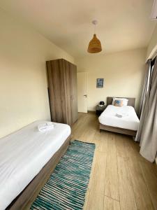 a bedroom with two beds and a rug at B-eight in Batroûn +1 photo