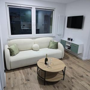 a living room with a white couch and a table at Apartament "Agatka" in Hel