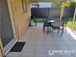a patio with a table and chairs on it at Eden Cottage in Woorim