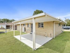 a house with a covered patio in front of it at Eden Cottage in Woorim