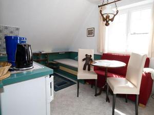 a small kitchen with a table and a couch with a teddy bear on it at Ferienwohnungen Morsum - Bleicken in Morsum