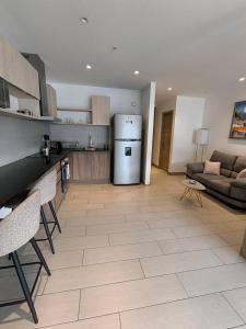 a kitchen and living room with a refrigerator and a couch at ONE Luxury Suite Super King Bed & Volcano View in Quito +10 photos