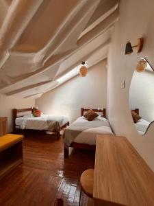 a bedroom with two beds in a room with a ceiling at Casa Terra Cusco in Cusco