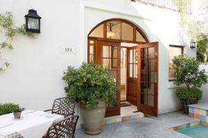 a patio with a wooden door and a table and chairs at Coopmanhuijs Boutique Hotel & Spa in Stellenbosch