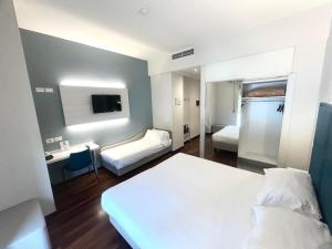 a hotel room with two beds and a desk at Best Western Cesena Hotel in Cesena