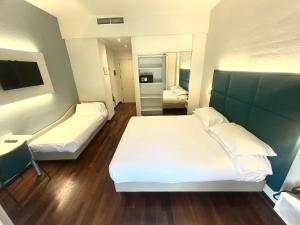 a hotel room with two beds and a mirror at Best Western Cesena Hotel in Cesena
