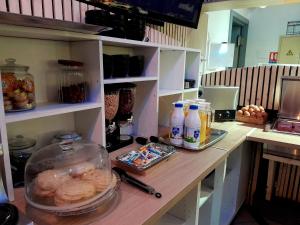 a kitchen with a counter with food and drinks on it at Hôtel NOROTEL in Brumath +24 photos